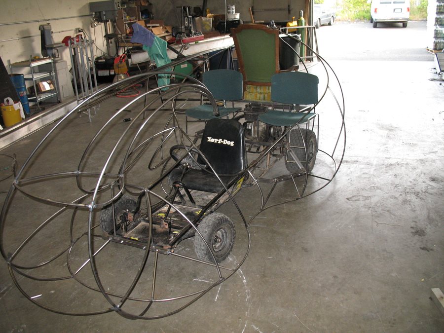 A stretched go-kart chassis with steel wire frame.